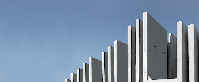 Winkelstützen + Sonderbauteile Winkelstützen aus Beton vor blauem Himmel